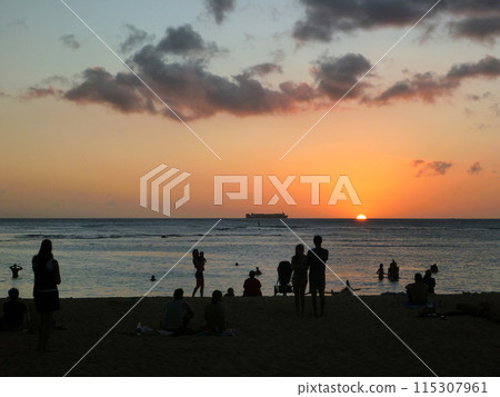 People watch dramatic Sunset on San Souci Beach 115307961