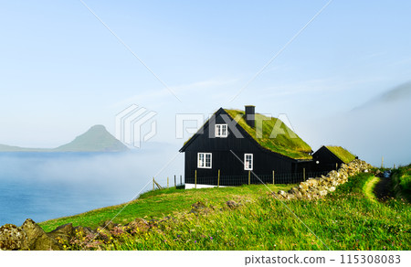 Black wooden faroese house with turf-top grass roof Black wooden faroese house with turf-top grass roof 115308083
