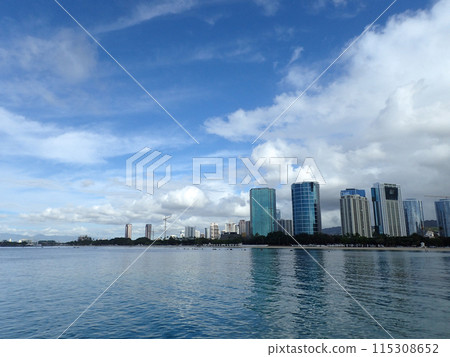 Glassy water of Ala Moana Beach with Condo buildings and construction cranes in the distance Glassy water of Ala Moana Beach with Condo buildings and construction cranes in the distance 115308652