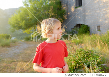 Preteen boy visiting of Fort Kosmach in Montenegro. Fortress is located near Budva. Old castle was built in Austro-Hungarian Empire as defensive structure and observation post. 115308677