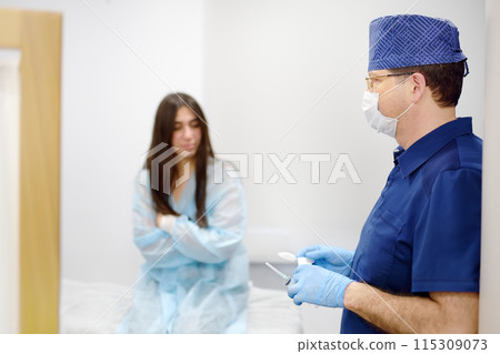 Mammalogist doctor is preparing to examine woman breasts and lymph nodes using ultrasound for diagnosis of breast cancer during appointment. Oncologist holding biopsy slide glasses and syringe. 115309073