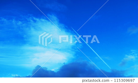 A beautiful scene of a contrail stretching straight into the blue sky A beautiful scene of a contrail stretching straight into the blue sky 115309697
