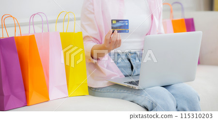 Young asian woman sitting on sofa using laptop computer shopping online with credit card. Young asian woman sitting on sofa using laptop computer shopping online with credit card. 115310203