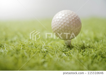 Closeup of golf ball on tee in lush grass Closeup of golf ball on tee in lush grass 115310646