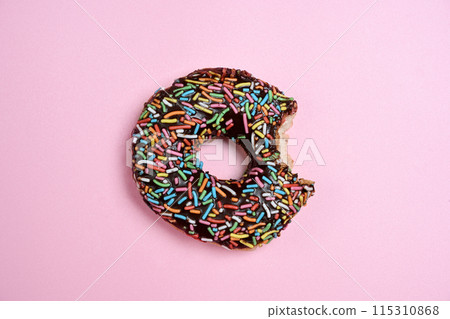 Delicious donut with a colorful sprinkle decoration bitten 115310868