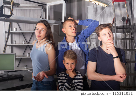 Brooding family tries to find a solution to a puzzle in a quest room 115311031