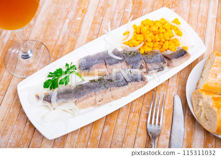 Sliced herring with corn and herbs on rectangular plate 115311032