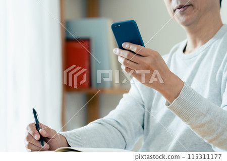 中年男子檢查他的智慧型手機 115311177