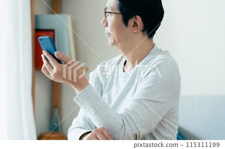 Middle-aged man checking his smartphone 115311199