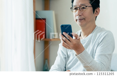 中年男子檢查他的智慧型手機 115311205