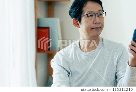 Middle-aged man checking his smartphone Middle-aged man checking his smartphone 115311210