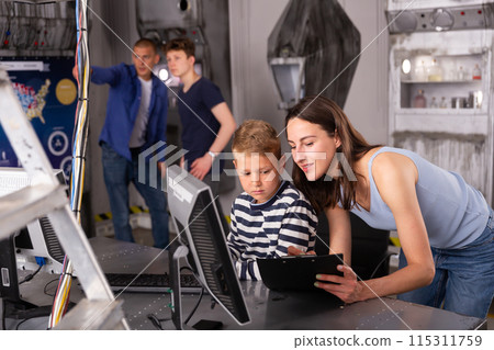 Portrait of a mother and son in front of a computer in the quest room 115311759