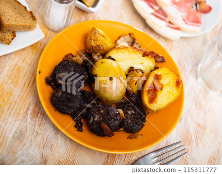Fried blood sausage with potatoes served at plate 115311777