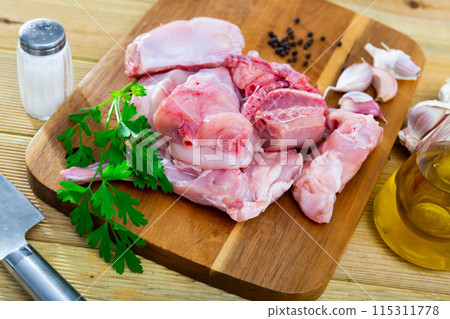 Chopped fresh raw rabbit with greens, garlic and spices on wooden cutting board Chopped fresh raw rabbit with greens, garlic and spices on wooden cutting board 115311778
