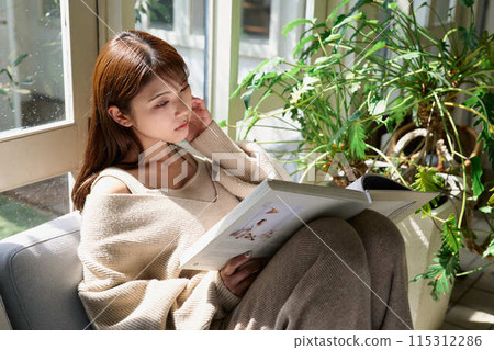 Woman reading by the window Woman reading by the window 115312286