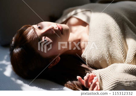 一個女人睡在窗邊的陽光下 115312332