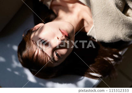 一個女人睡在窗邊的陽光下 115312333