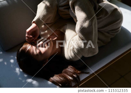 一個女人睡在窗邊的陽光下 115312335