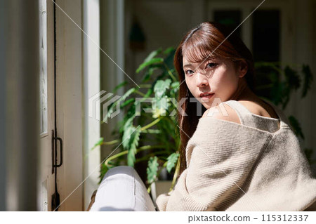 A woman sleeping by the window in the sunlight 115312337