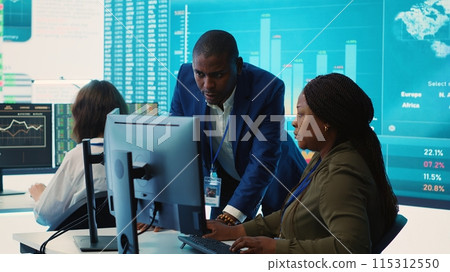 Financial analyst works on resource allocation plans with his staff, analyzing reports and sales infographics to find revenue. Achieve objectives in a competitive business environment. Camera A. 115312550