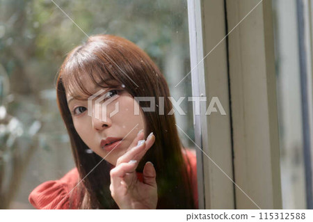 A young woman who opens the door 115312588