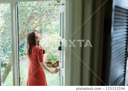 一個打開門的年輕女子 115312594