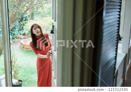 一個打開門的年輕女子 115312595