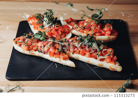 Vibrant Bruschetta Delight,A plate brimming with freshly made bruschetta topped with juicy tomatoes  115313273