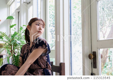A woman sitting on the window side 115313545