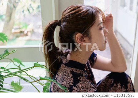 A woman sitting on the window side 115313553