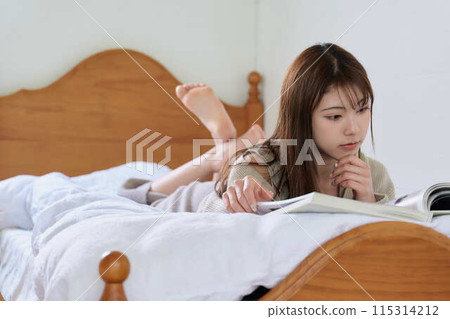 一個女人在床上看書 一個女人在床上看書 115314212