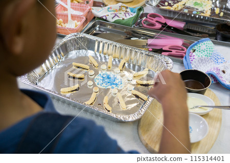 Elementary school children make crafts using chocolate and snacks in a cooking class 115314401