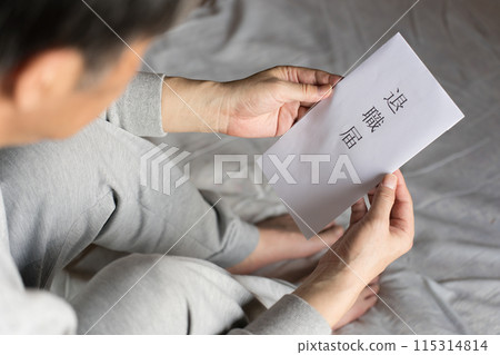 一位中年男子正在考慮是否使用家中的退休機構。 一位中年男子正在考慮是否使用家中的退休機構。 115314814