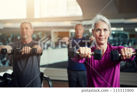 Mature group, woman and dumbbell in class for fitness, coaching and muscle development in gym. Senior people, men and exercise for arms, health and happy for weightlifting workout at wellness club 115315900