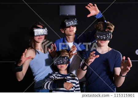 Cheerful family in vr goggles playing games together 115315901