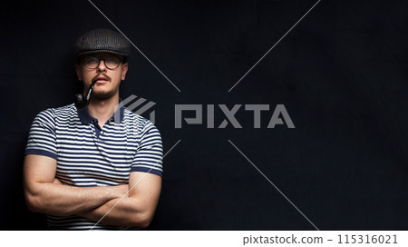Muscular sailor with crossed arms in a close-up portrait. Banner for design with copy space. Concept of masculinity. Black background Muscular sailor with crossed arms in a close-up portrait. Banner for design with copy space. Concept of masculinity. Black background 115316021