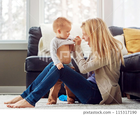 Home, smile and dressing of baby by mom, living room and playful with son, love and care in apartment. House, mother and toddler in lounge, clothes and fun together, happiness and wellness for boy Home, smile and dressing of baby by mom, living room and playful with son, love and care in apartment. House, mother and toddler in lounge, clothes and fun together, happiness and wellness for boy 115317190