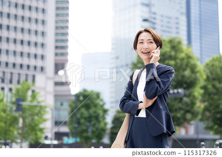 商務中年女性用智慧型手機交談 商務中年女性用智慧型手機交談 115317326