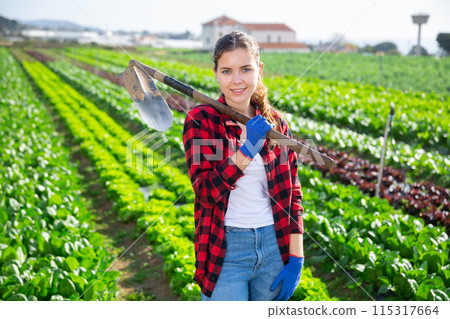 Portrait of young woman with gardening tools standing outdoors Portrait of young woman with gardening tools standing outdoors 115317664
