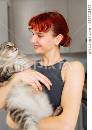 portrait red-haired teenage girl with gray fluffy cat 115318303