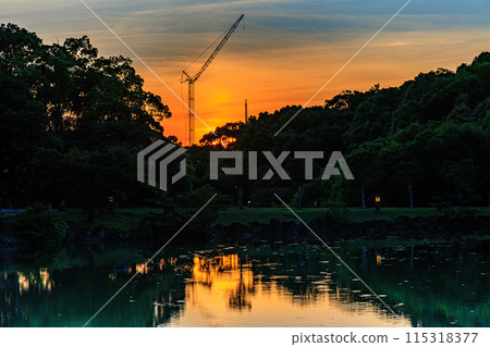 Evening view of Ukimido Hall at Sagiike Pond in Nara Park: The sun setting over Kofukuji Temple while painting the western sky golden ① Evening view of Ukimido Hall at Sagiike Pond in Nara Park: The sun setting over Kofukuji Temple while painting the western sky golden ① 115318377