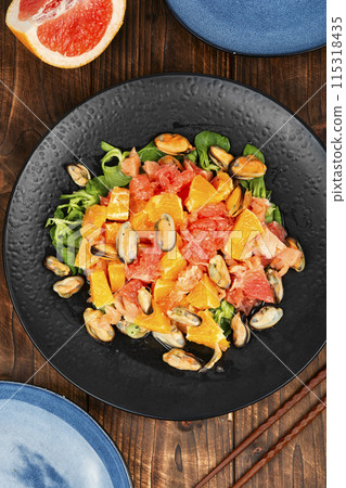 Salad with citrus and seafood on a rustic background. Salad with citrus and seafood on a rustic background. 115318435