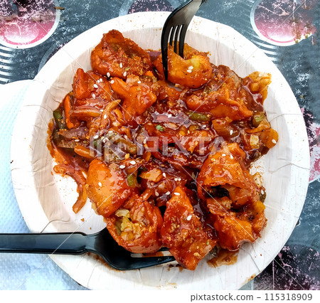 Image of Veg Manchurian Momos garnished in a disposable plate 115318909