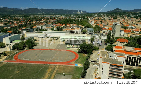 Aerial shot of the school sportsground cityscape of Montelimar and distant nuclear power plant. Ardeche and Drome departments of France Aerial shot of the school sportsground cityscape of Montelimar and distant nuclear power plant. Ardeche and Drome departments of France 115319204