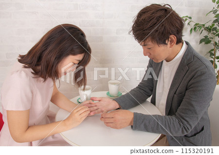 A couple reading each other's palms at a coffee shop during a date 115320191