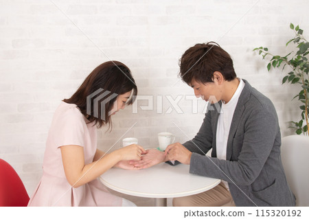 A couple reading each other's palms at a coffee shop during a date A couple reading each other's palms at a coffee shop during a date 115320192