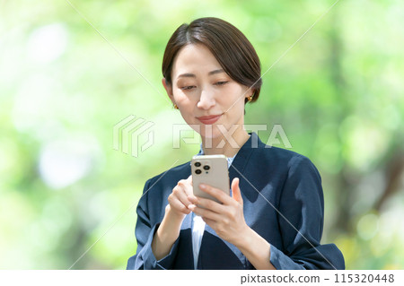 Middle-aged woman operating a smartphone 115320448