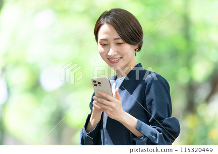 Middle-aged woman operating a smartphone Middle-aged woman operating a smartphone 115320449