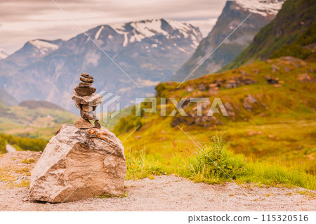 Stone stack and snowy mountain tops, Norway Stone stack and snowy mountain tops, Norway 115320516