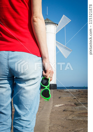 Woman with sunglasses in shape of heart on west breakwater Woman with sunglasses in shape of heart on west breakwater 115321878